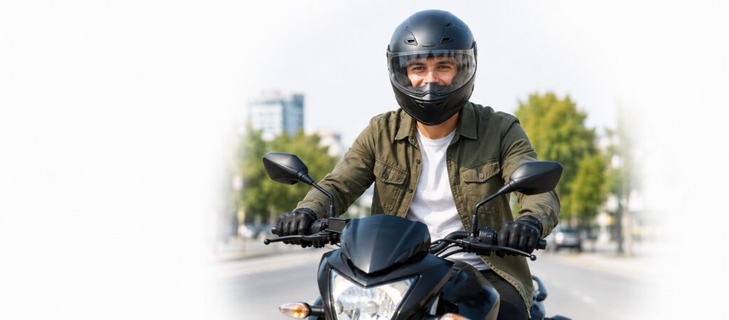 Motociclista con casco conduciendo por la ciudad, protegido por el seguro de moto de Prointel